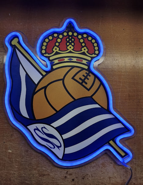 Escudo de futbol liga 1º division del Club Real sociedad,Diseño con medidas metacrilato 40x35cm aproximadamente dependiendo el diseño del escudo con neon led,metacrilato y vinilo color.Alimentacion 12v,cable 2m y cadena para colgar en pared incluido.