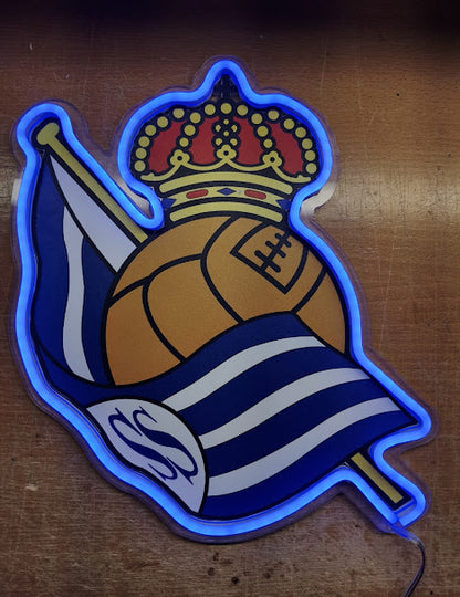 Escudo de futbol liga 1º division del Club Real sociedad,Diseño con medidas metacrilato 40x35cm aproximadamente dependiendo el diseño del escudo con neon led,metacrilato y vinilo color.Alimentacion 12v,cable 2m y cadena para colgar en pared incluido.